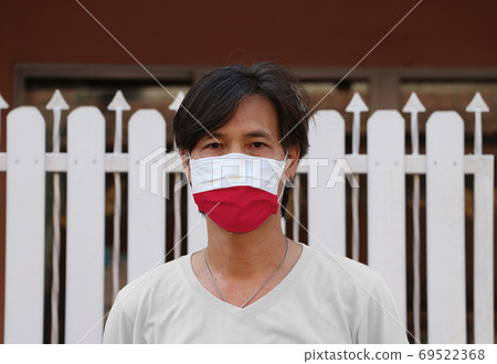 Poland flag on hygienic mask. Masked Asian man prevent germs. co 69522368