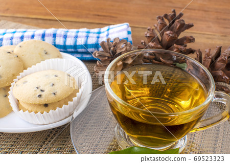 A glass cup of black tea with cookies on a dark greyish marble b A glass cup of black tea with cookies on a dark greyish marble b 69523323