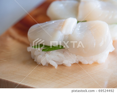 Close-up of scallop sushi. A handful of scallops with perilla between vinegared rice. 69524492