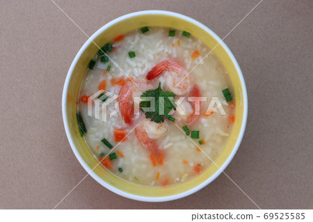 Rice congee mixed with shrimp in the round bowl on the brown floor. 69525585