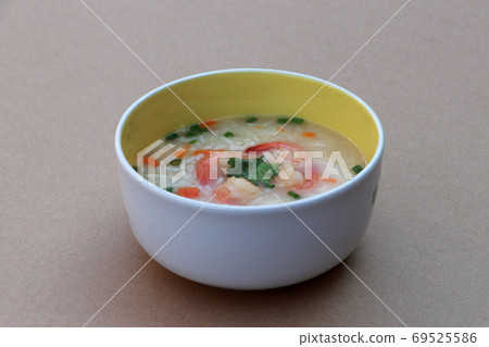 Rice congee mixed with shrimp in the round bowl on the brown floor. Rice congee mixed with shrimp in the round bowl on the brown floor. 69525586