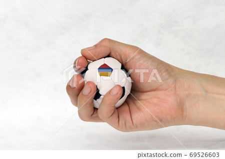 Mini football in hand and one black point of football is Armenia flag on white background. Mini football in hand and one black point of football is Armenia flag on white background. 69526603