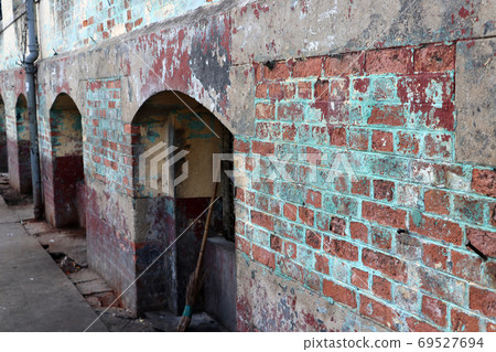 Old grungy brick wall with arched door. Old grungy brick wall with arched door. 69527694
