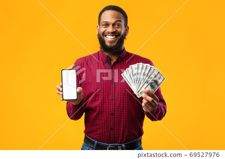 Afro guy holding mobile phone and bunch of money cash Afro guy holding mobile phone and bunch of money cash 69527976