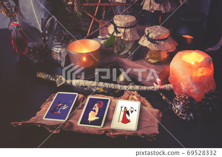 3 Tarot cards spread lying on a black table with magic items. Toned to cold colors 3 Tarot cards spread lying on a black table with magic items. Toned to cold colors 69528332