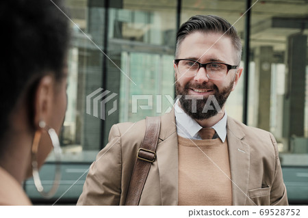 Man talking to his colleague 69528752