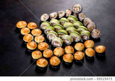 Fresh delicious beautiful sushi rolls on a dark background 69529473