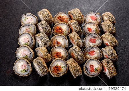 Fresh delicious beautiful sushi rolls on a dark background 69529474