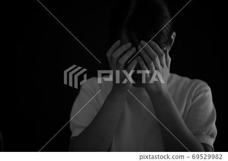 A woman who covers her face by hand 69529982