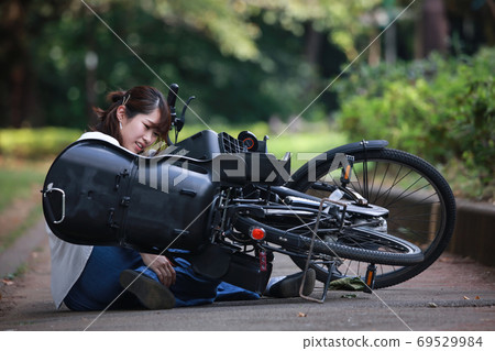 Woman falling down on a bicycle Woman falling down on a bicycle 69529984