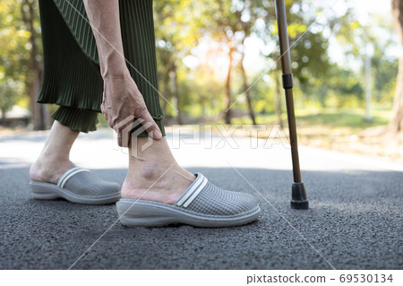 Closeup of legs of senior woman feeling pain in the joints bones,ankle tendon injury,gout disease,osteoarthritis,ligament and muscle problems,elderly people touching ankle due to sprain after walk 69530134