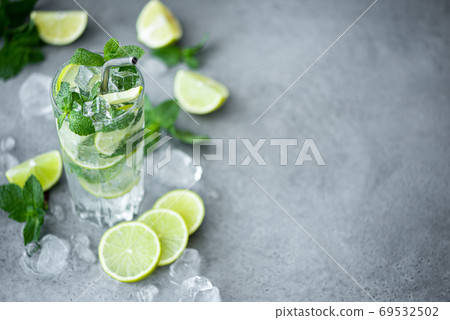 mojito cocktail with mint, lime and ice in a tall glass mojito cocktail with mint, lime and ice in a tall glass 69532502