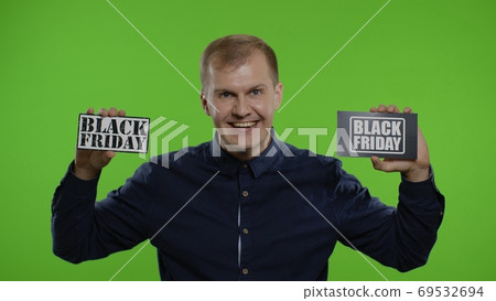 Happy shopper guy showing Black Friday inscriptions notes, looking at camera amazed. Big sale day 69532694