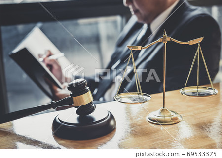 Male lawyer or judge working with contract papers, Law books and 69533375