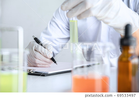 Scientist or medical in lab coat holding test tube with reagent, Scientist or medical in lab coat holding test tube with reagent, 69533497