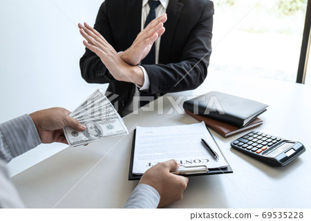 Businessman refusing receive bribe money of their Businessman refusing receive bribe money of their 69535228