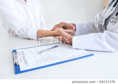 Doctor checking measuring pressure on patient's Doctor checking measuring pressure on patient's 69535376