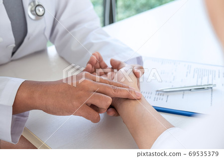 Doctor checking measuring pressure on patient's Doctor checking measuring pressure on patient's 69535379