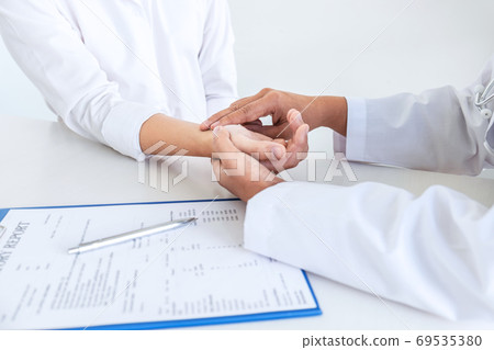 Doctor checking measuring pressure on patient's 69535380