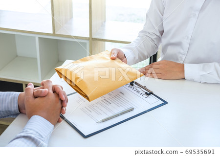 Businessman giving bribe money in the envelope of 69535691