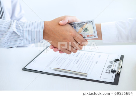 Businessman handshake with money of dollar Businessman handshake with money of dollar 69535694