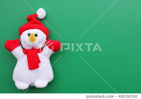 Toy smiling snowman on a green background. Toy smiling snowman on a green background. 69536592
