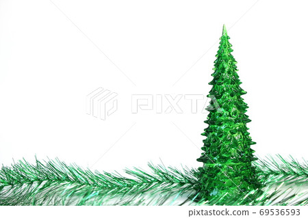 Green toy Christmas tree and tinsel are isolated on white background. Copy space. Green toy Christmas tree and tinsel are isolated on white background. Copy space. 69536593