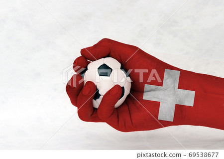 Mini ball of football in Switzerland flag painted hand on white background. Mini ball of football in Switzerland flag painted hand on white background. 69538677