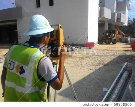 KUALA LUMPUR, MALAYSIA -JULY 16, 2020: Surveyor with survey equipment at the construction site. Surveyors help set the location and level at the construction site. 69538806
