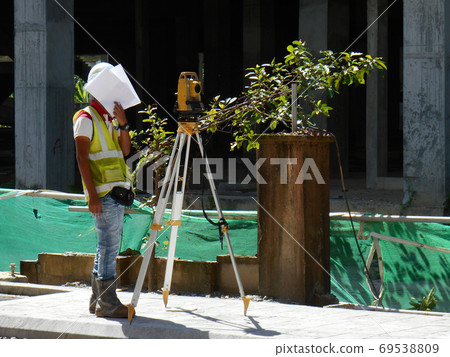 KUALA LUMPUR, MALAYSIA -JULY 16, 2020: Surveyor with survey equipment at the construction site. Surveyors help set the location and level at the construction site. 69538809