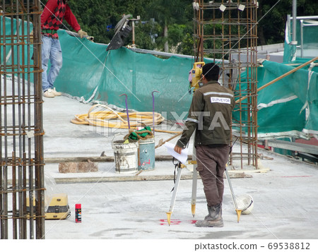 KUALA LUMPUR, MALAYSIA -JULY 16, 2020: Surveyor with survey equipment at the construction site. Surveyors help set the location and level at the construction site. 69538812