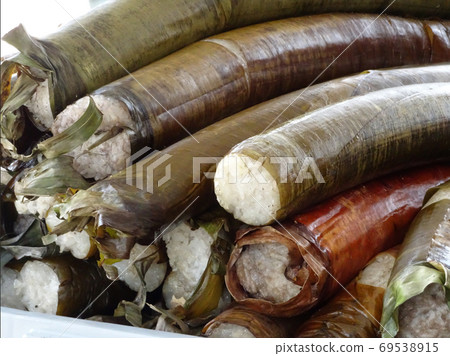 Malaysian famous traditional food called lemang. Glutinous rice wrapped with banana leave and steamed in a bamboo. Malaysian famous traditional food called lemang. Glutinous rice wrapped with banana leave and steamed in a bamboo. 69538915