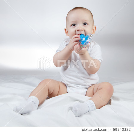 Photo of a ten-month-old baby with blue rattle 69540322