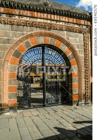 Arch with a patterned border of black and red tuff with black oval wrought iron gates on the fence of the house Dzitokhtsyan XIX century in Gyumri Arch with a patterned border of black and red tuff with black oval wrought iron gates on the fence of the house Dzitokhtsyan XIX century in Gyumri 69540376