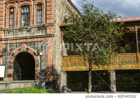 Beautiful 19th century Dzitoghtsyan house with oval entrance and wrought iron gate next to a wooden carved balcony in Gyumri Beautiful 19th century Dzitoghtsyan house with oval entrance and wrought iron gate next to a wooden carved balcony in Gyumri 69540382