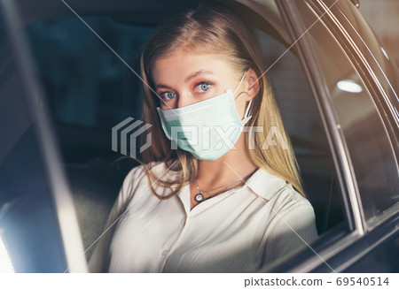 New normal. Teenager sitting in the back of a car with a mask. Y New normal. Teenager sitting in the back of a car with a mask. Y 69540514