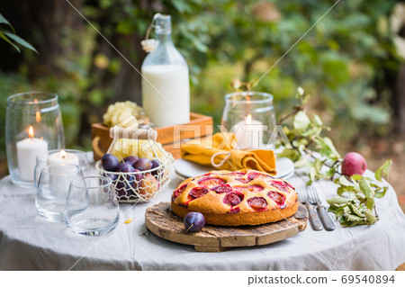 Traditional homemade plum cake or pie with summer table setting Traditional homemade plum cake or pie with summer table setting 69540894