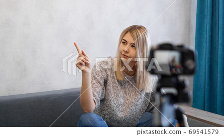 The woman shows with on a gray wall. Place for information 69541579