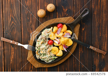 Fried chanterelles, honey mushrooms and potato wedges with creamy sauce Fried chanterelles, honey mushrooms and potato wedges with creamy sauce 69542578