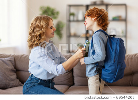 Mother preparing son for school studies. Mother preparing son for school studies. 69544205