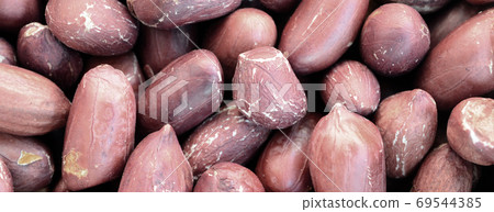 Peanut. A lot of small yellow nuts with brown peel. Background t Peanut. A lot of small yellow nuts with brown peel. Background t 69544385