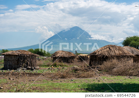 Traditional Maasai Village with Clay Round Huts in Engare Sero area near Lake Natron and Ol Doinyo Lengai volcano in Tanzania, Africa 69544726