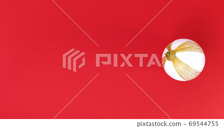 White and gold Christmas tree ball on a red background. Minimalistic holiday flat lay with copy space. 69544755