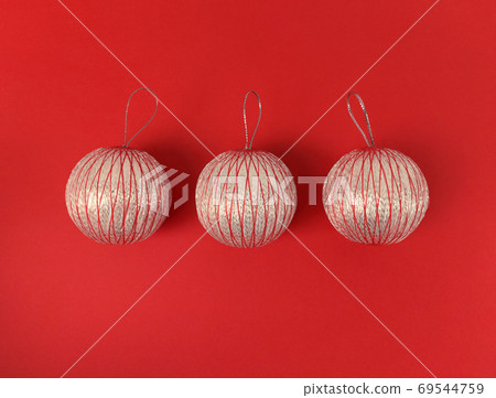 Three Christmas balls on a red background. Minimalistic holiday flat lay. Three Christmas balls on a red background. Minimalistic holiday flat lay. 69544759