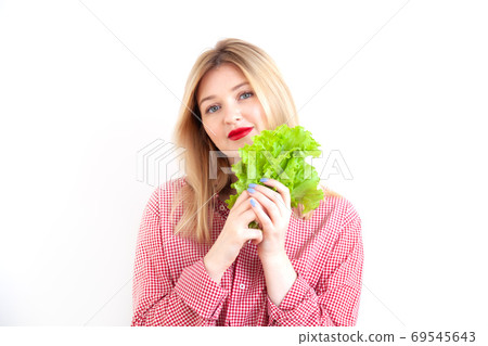 Young beautiful woman holding salad leaves on white background Young beautiful woman holding salad leaves on white background 69545643