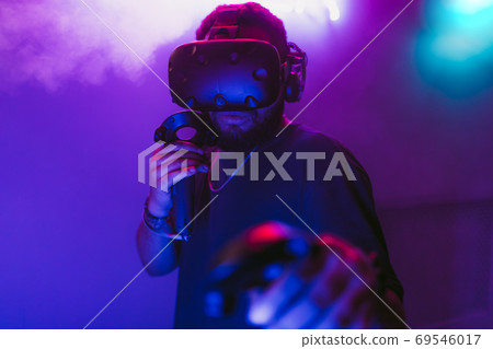 Man in a virtual reality helmet. Neon room with VR games. 69546017