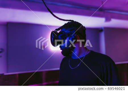 VR E-Sports. The guy is playing an online shooter in the game neon room. 69546021