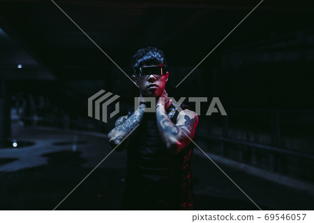 Night portrait of a man in futuristic glasses. A new trend of cyberpunk. Night portrait of a man in futuristic glasses. A new trend of cyberpunk. 69546057