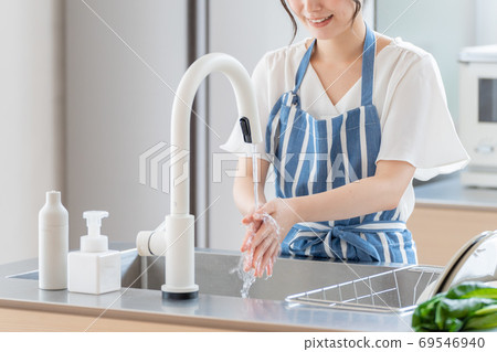 Woman washing hands in the kitchen 69546940