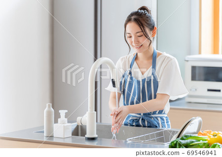 Woman washing hands in the kitchen Woman washing hands in the kitchen 69546941